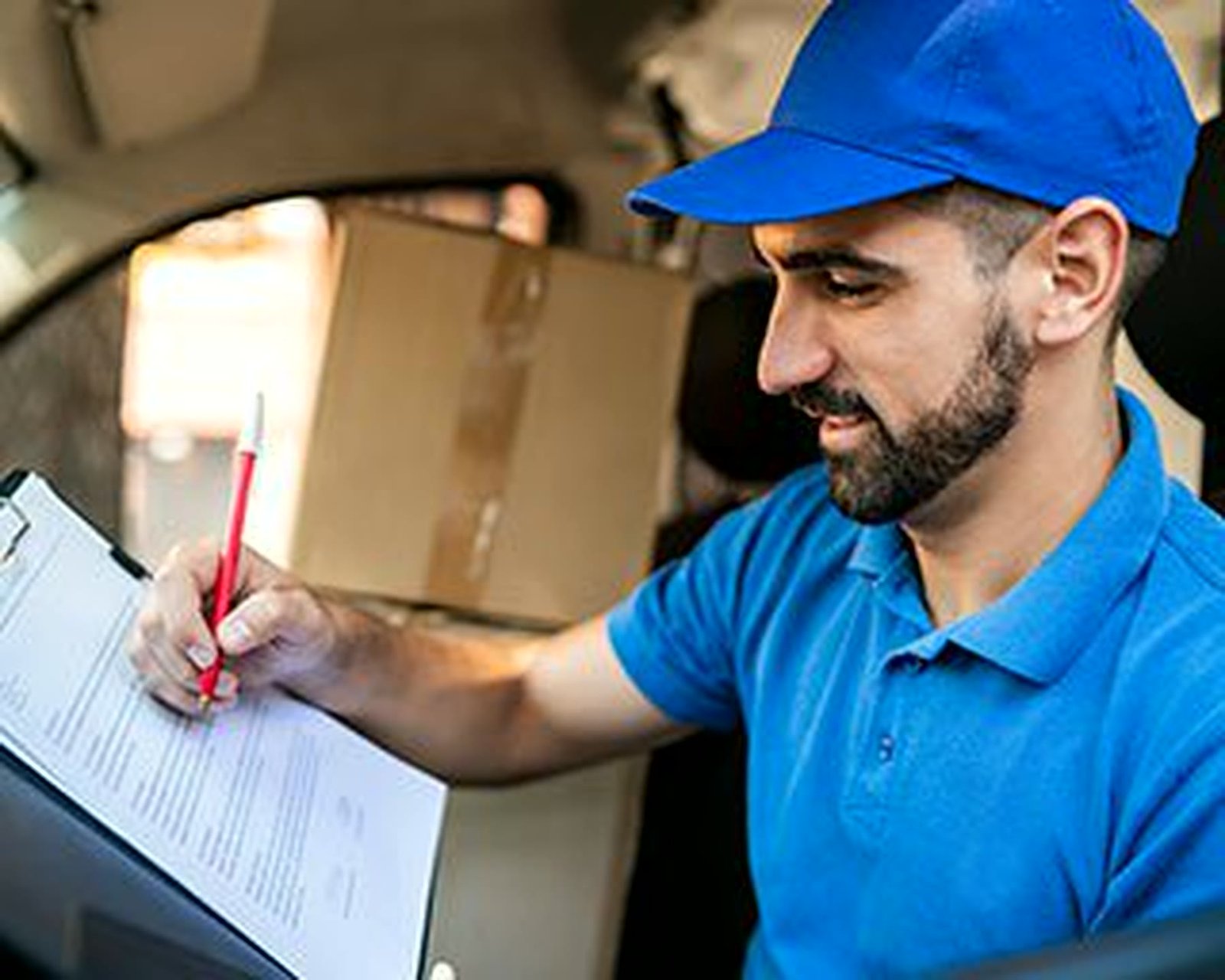 Courier driver completing delivery paperwork